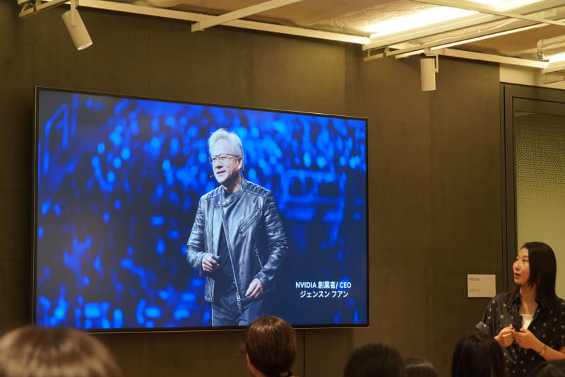 NVIDIAの創業者でCEOのジェンスン・ファン氏を紹介する広報シニアマネージャーの吉川香葉子氏。ジェンスン・ファンのアバターが散りばめられたシャツを着用中