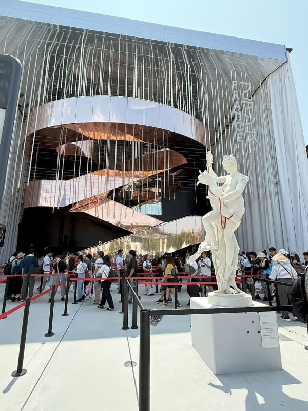 前衛的な“カーテン”向こうに、心躍る美しい世界が広がるフランス館。正面に立つ男女一体の像は、互いの小指が赤い糸で結ばれ、柔らかな曲線が印象的だ。