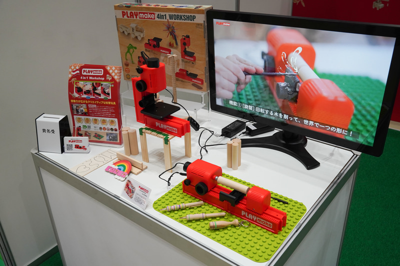 大人の世界を体験する玩具PLAYmakeの4in1工作キット。組み換えでドリル、糸のこ、旋盤までを安全に実現して、子供が実際に木工加工できるまさにものづくりの入門用の玩具。このようなものも多数展示される東京おもちゃショー