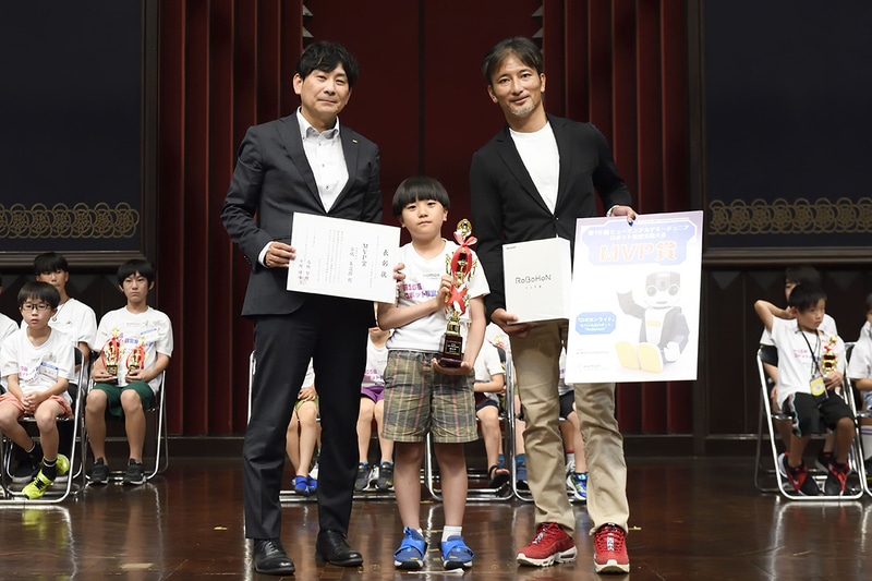 大会審査委員長とヒューマンアカデミー 代表取締役 今堀健治氏から賞状やトロフィーなどが贈られた