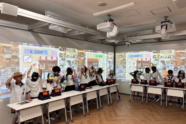 附属久留米小学校では、巨大スクリーンでリアルのようなお店を実現