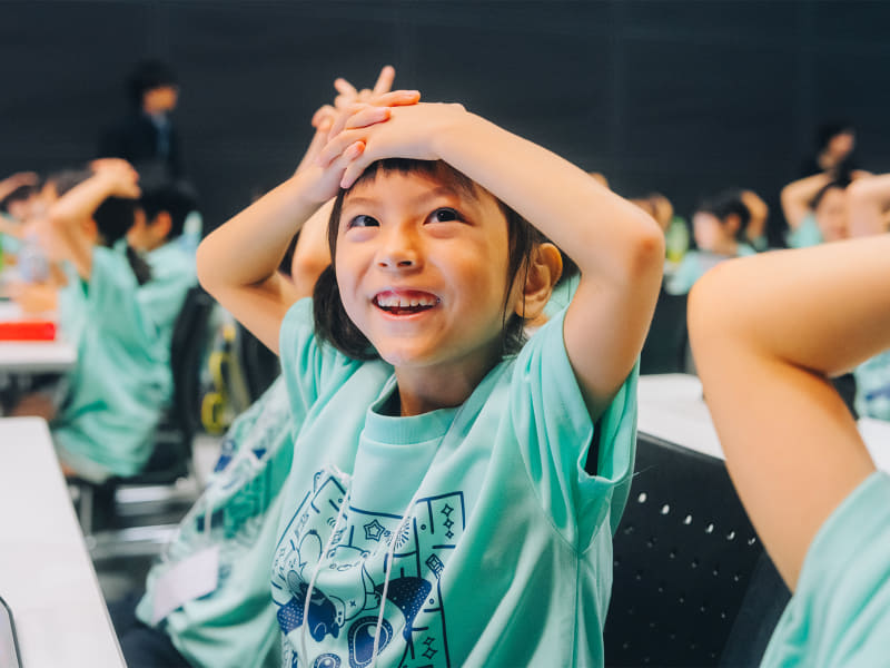 「手は頭」のポーズで待機する子供たち。熱い「思考バトル」が始まる