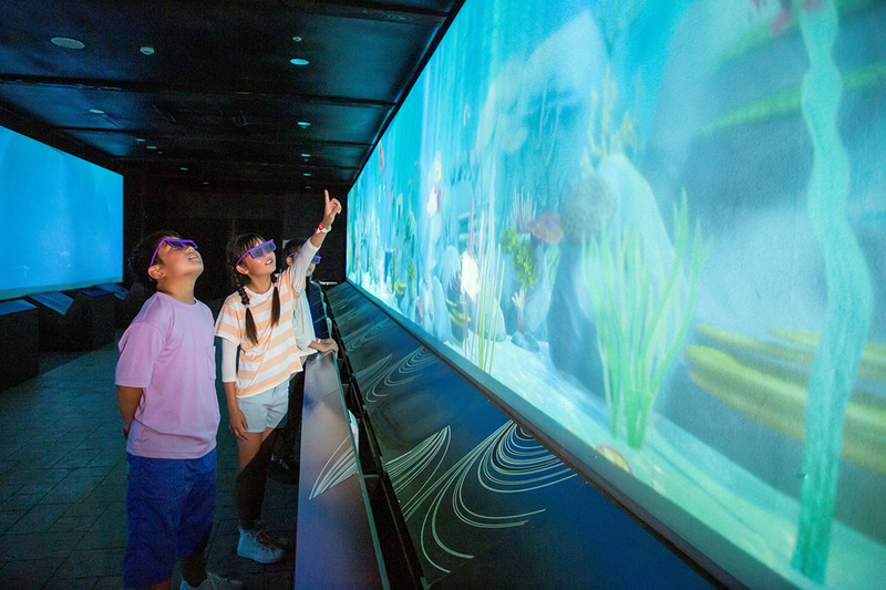 イラストが全長14メートルの巨大スクリーンで泳ぎ回る「3D水族館」