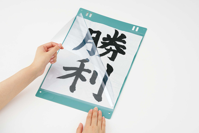 プラス株式会社が、児童生徒の書道作品を簡単・きれいに掲示できる「ワイドに開く書道作品ホルダー 半紙用」を2026年1月1日に発売（出典：プラス株式会社、以下同じく）