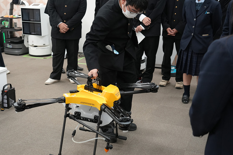農業×ICTの展示では、軽量化されたドローンも見学。軽トラックに積みやすいサイズや高齢の農業者でも扱いやすくする工夫を聞き、実際に持ち上げて重さを確かめた