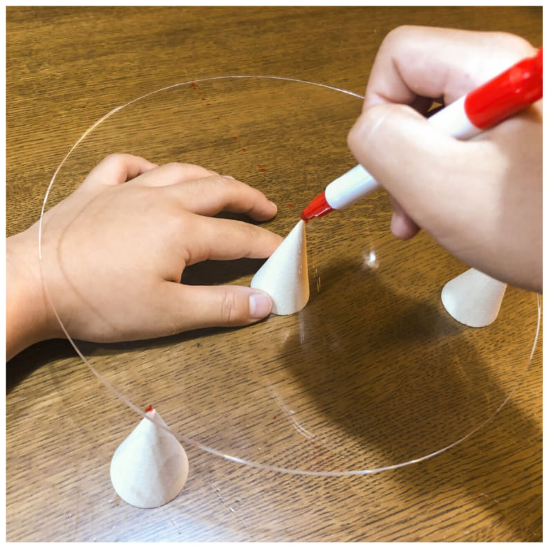 菊地さんが行った「3本あしのひみつ」の実験。アクリル板にマーカーで点を付けていく（出典：講談社えほん通信のWebサイトより）