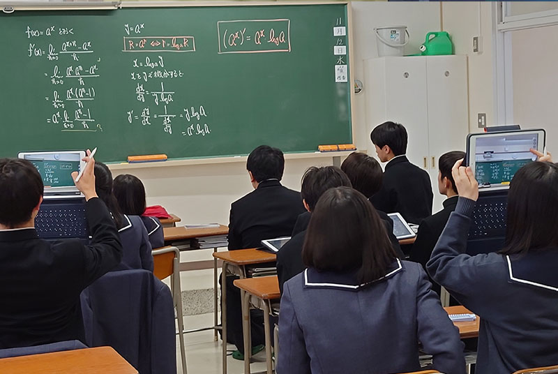 カメラで板書を撮影する生徒たち