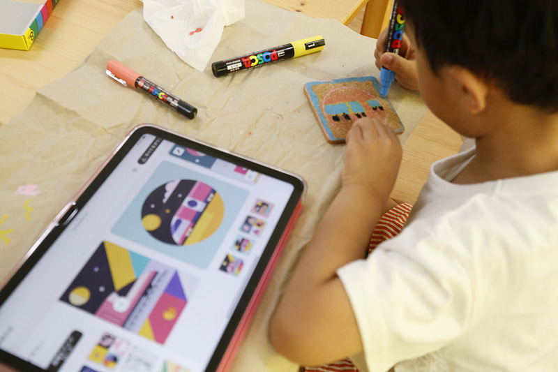 AIで自分の名前と好きなものを組み合わせたデザインを考え、オリジナルコースターをつくる子供