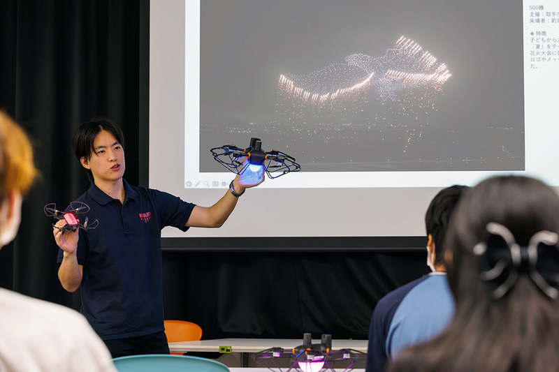 株式会社レッドクリフ 代表取締役／CEOの佐々木孔明氏が、過去に開催したドローンショーやドローンに関する説明をする様子