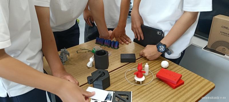 岡山大学の学生サポーターが持ち込んだ、3Dプリンターによる作製物を囲んで語り合う生徒たち（写真提供：岡山芳泉高等学校、Mosademy、岡山大学）