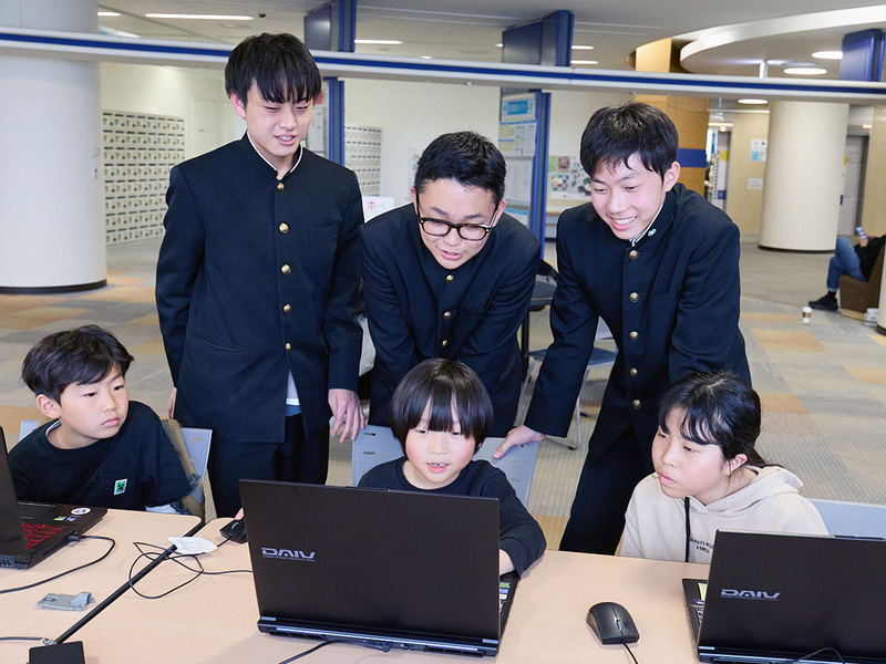 協賛機材を活用したワークショップを実施。岸中学校を卒業した理科部デジタルクリエイティブ科の生徒たちが講師となり、子供たちをサポート