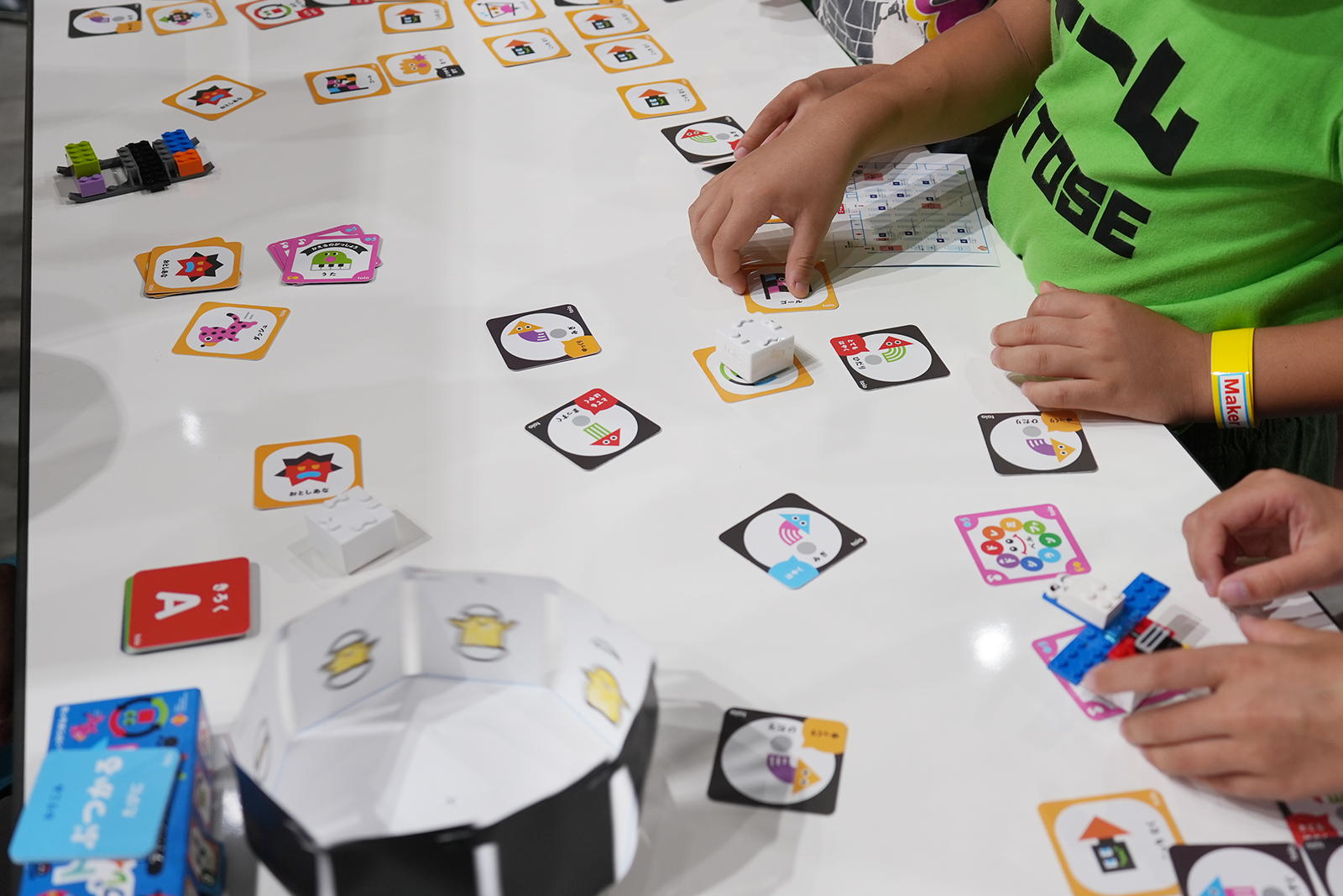 レゴブロックなどを取り付けたtoioを、カードの上で走らせる子供たち
