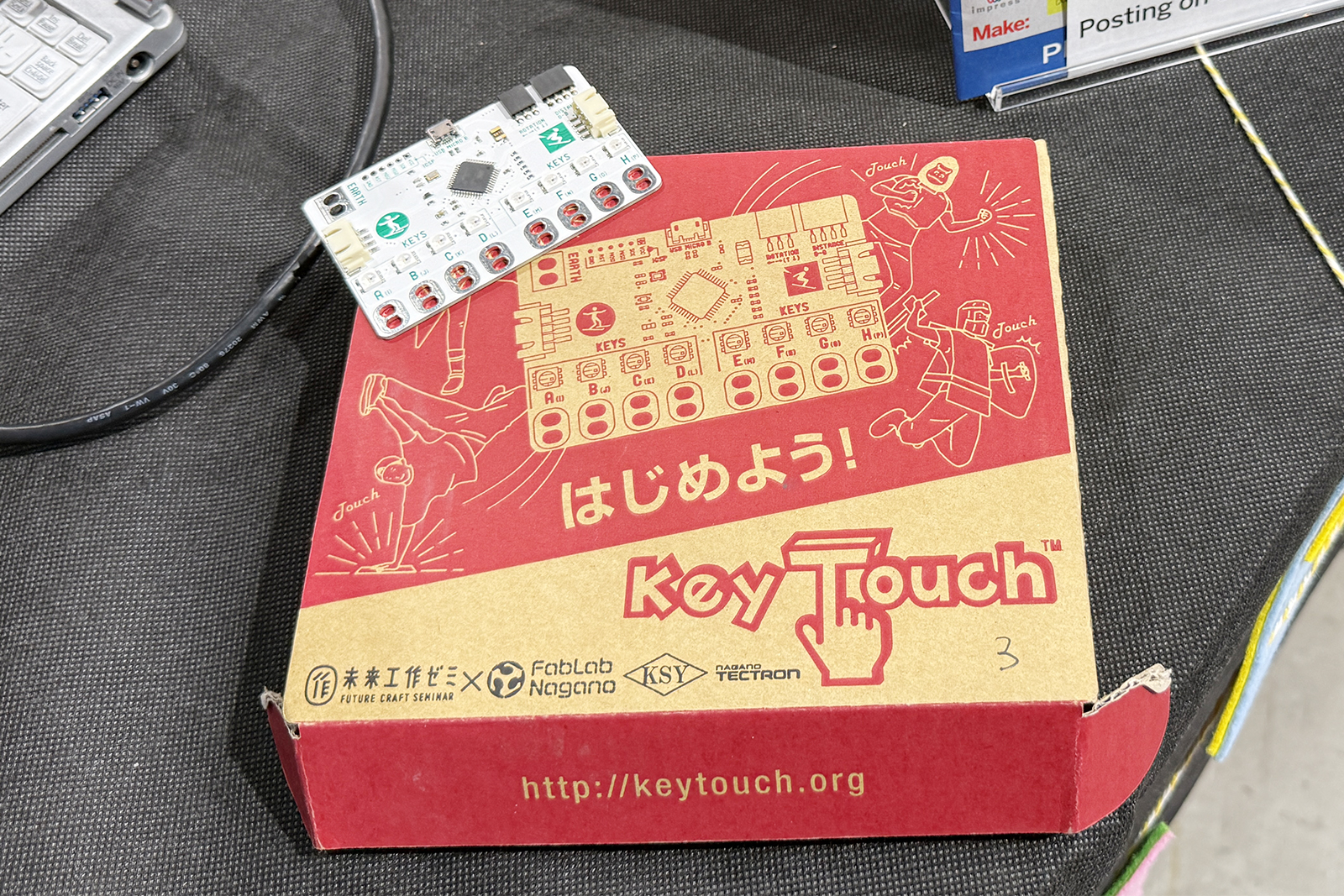 未来工作ゼミ、FabLab Nagano、KSYなどが共同開発したプログラミング学習ツール「Key Touch」。箱の上に置かれた基板が本体