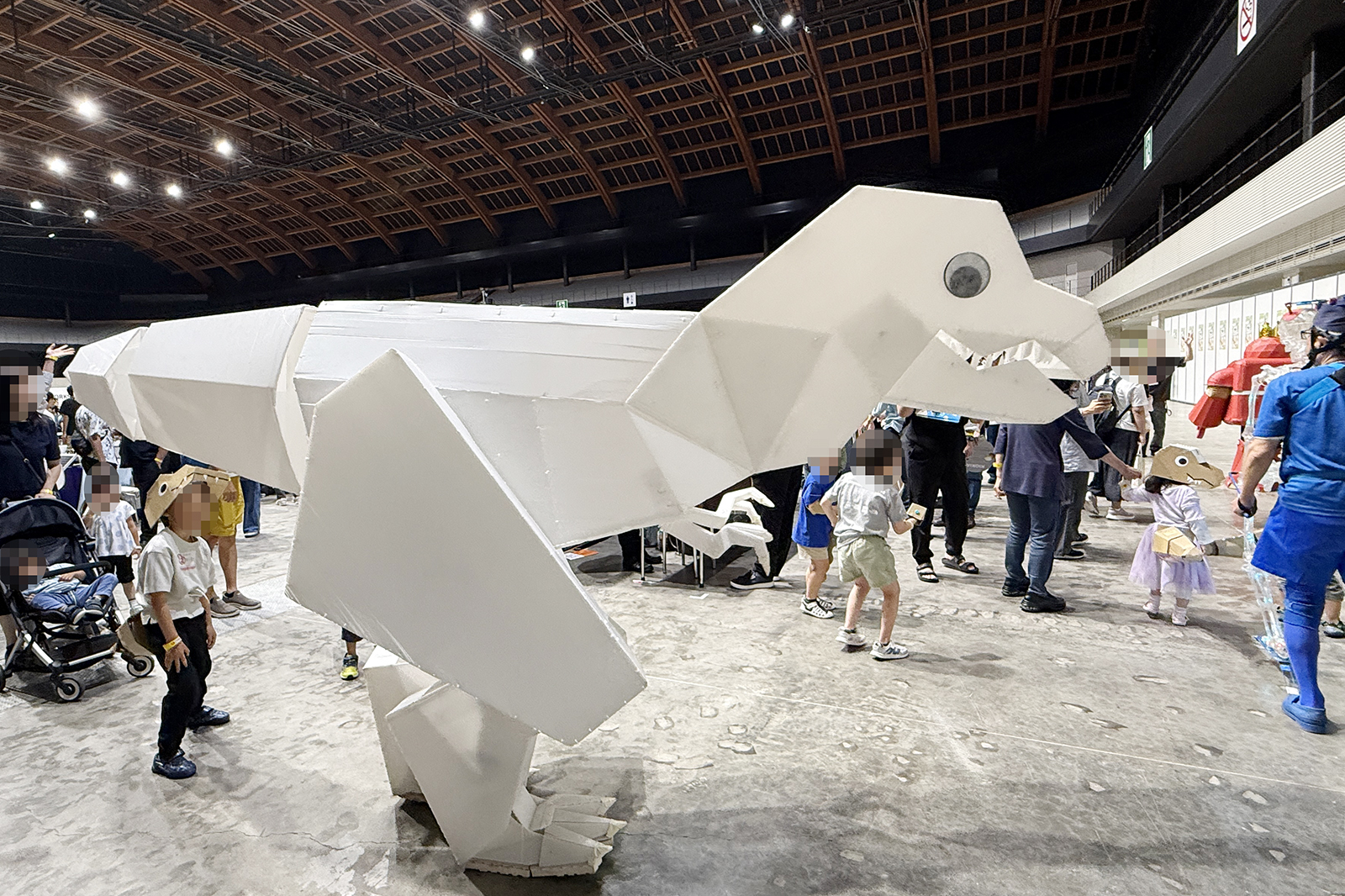 会場を闊歩する大きなティラノサウルス。後ろには小さな恐竜たちも