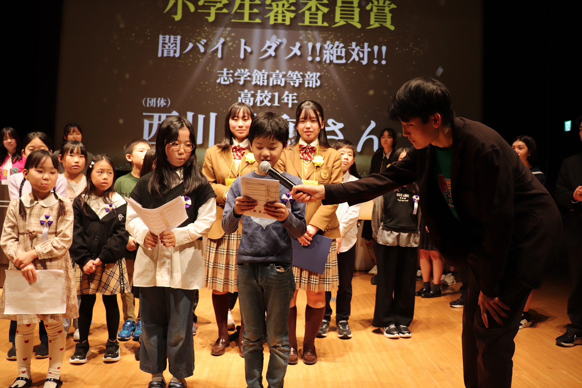 昨年度の全国大会表彰式で「小学生審査員賞」を授与する様子