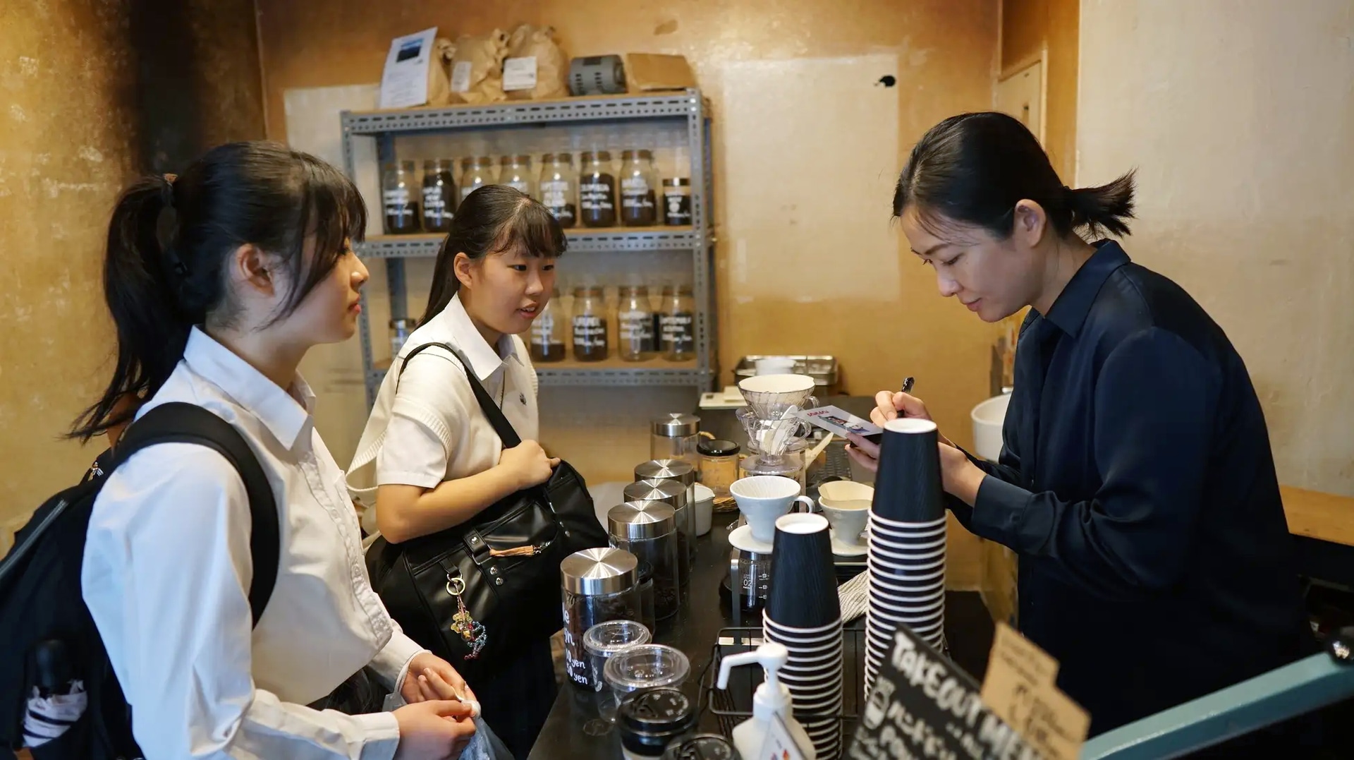 学校近隣のカフェで聞き取り調査を行う生徒たち