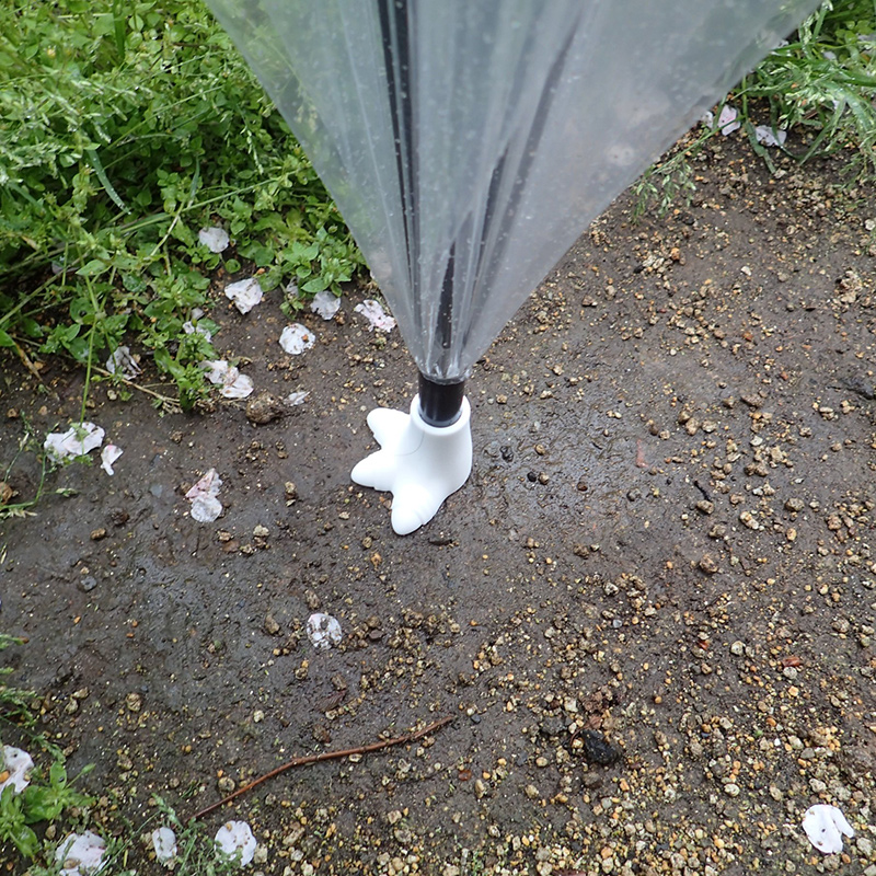 雨の中、傘をたたんで強くプッシュするもなかなか足跡は地面に付かない。都会の土の表面は意外と硬いのだ（左）<br>しつこく強く地面を押して、傘の軸が折れそうになってやっとこういう感じだ（右）