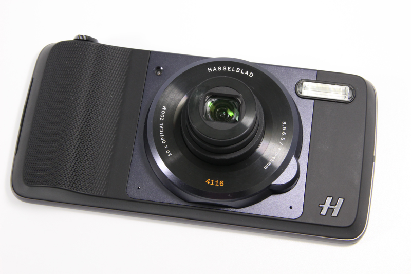 「ハッセルブラッド TRUEZOOM」。Moto Zシリーズに装着して利用する光学10倍のズームカメラ。1200万画素センサーと、フラッシュ、シャッターボタン、ズームレバーを搭載。サードパーティーのカメラアプリも利用できる