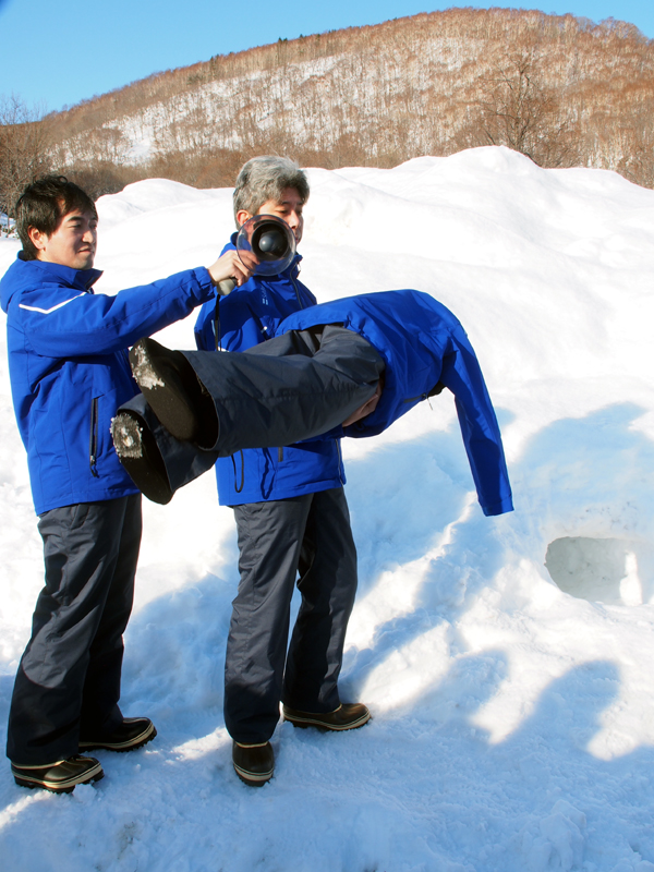 人形のポケットにスマートフォンを入れ、雪の中に埋めた