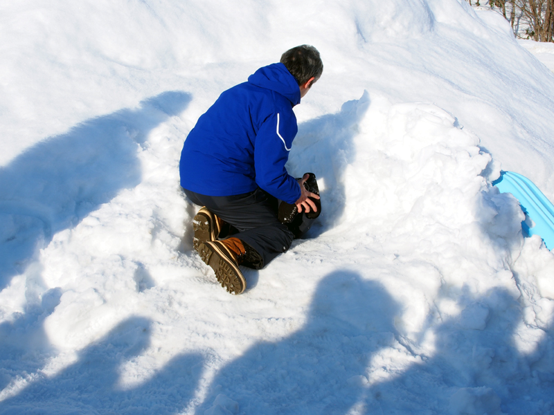 人形のポケットにスマートフォンを入れ、雪の中に埋めた