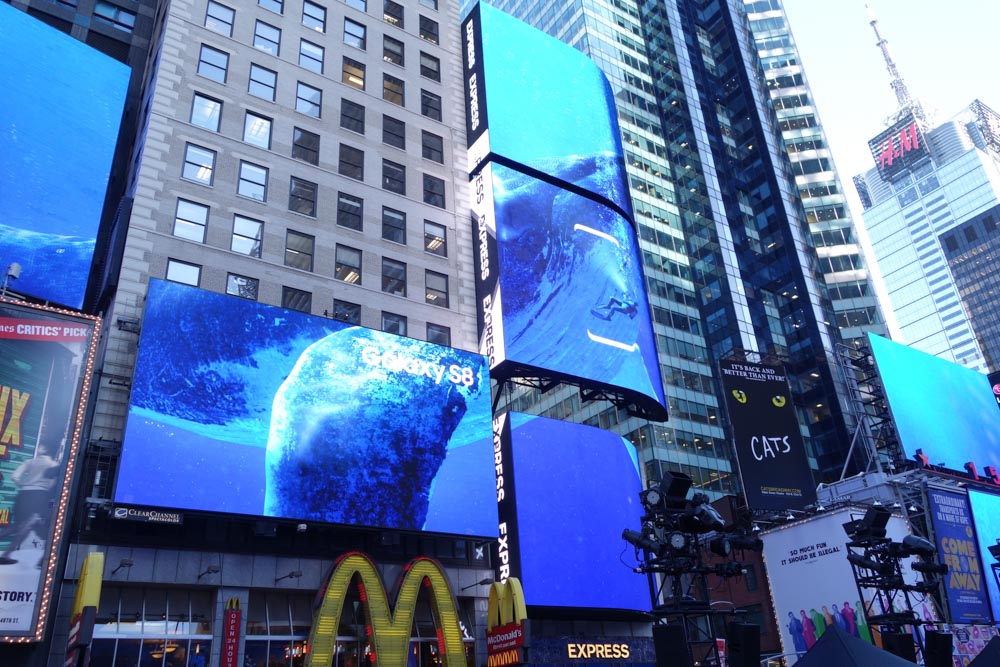 複数のビルボードにまたがってクジラが泳いでいる