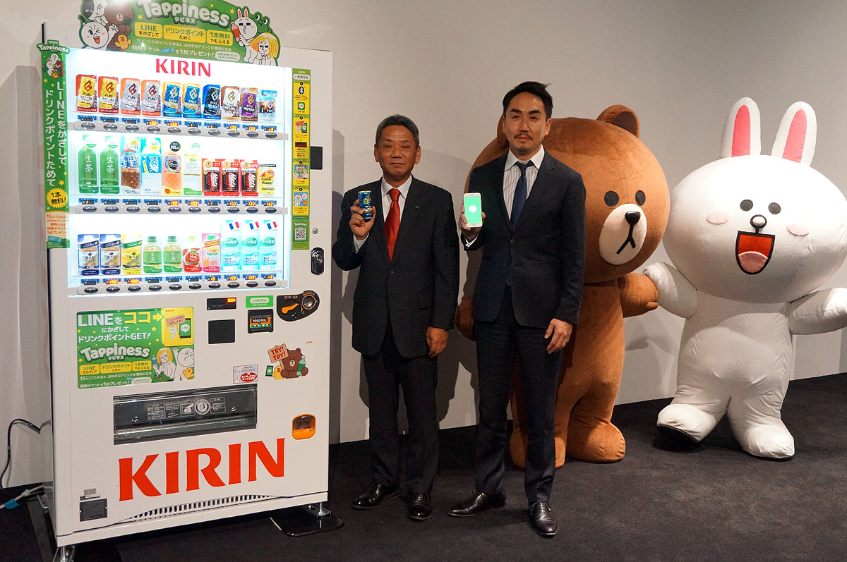 キリンの自販機と並ぶ、キリンビバレッジバリューベンダーの岩田氏とLINEの出澤氏