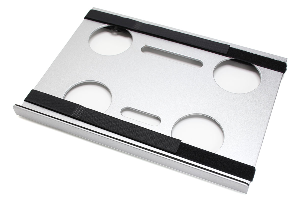 サンコーの「カメラ三脚用ノートPCデスク CLHCMAL2」。左が表面、右が裏面。アルミ製のテーブル部品で、三脚ネジ穴により三脚の上にセットできます。黒いものはノートPCを固定するための面ファスナーベルトで、取り外せます。