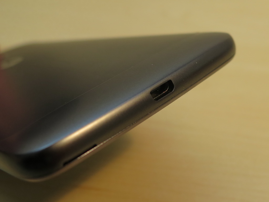 底面側はmicroUSB外部接続端子。写真左手前側の切り欠きの部分に爪をかけると、背面カバーを取り外すことができる。