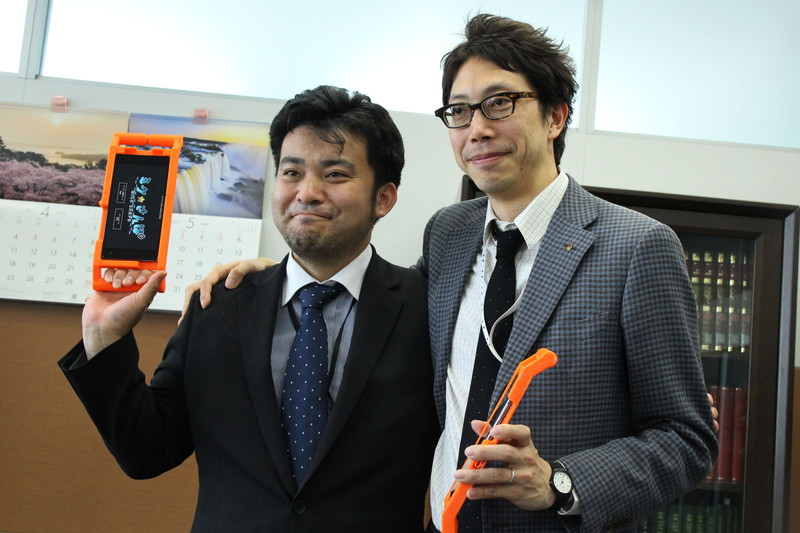 KDDI 商品開発本部 ホーム・IoTサービス企画部 サービス開発グループ マネージャーの水田修氏（右）と、コンテンツを担当したKDDI 商品企画本部 パーソナルサービス企画部 コミュニケーションサービスグループ 課長補佐の増崎和彦氏