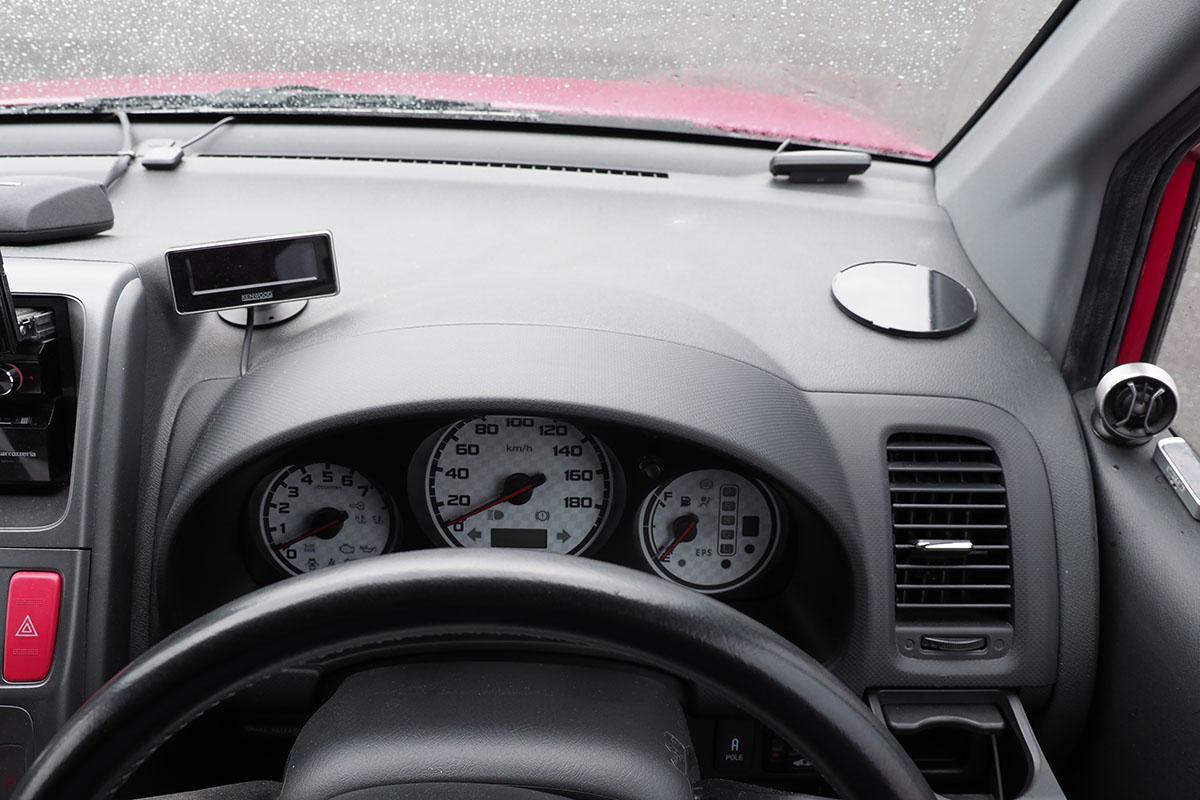 各種スマートフォンホルダーを装着する車内。運転席右側のダッシュボード上に固定しました。固定位置には、ダッシュボードに貼り付けた吸盤用プレートがあります。このクルマのダッシュボード表面のシボ加工（凸凹加工）は少し深めで吸盤が外れることが多いので、こういったプレートを使っています。