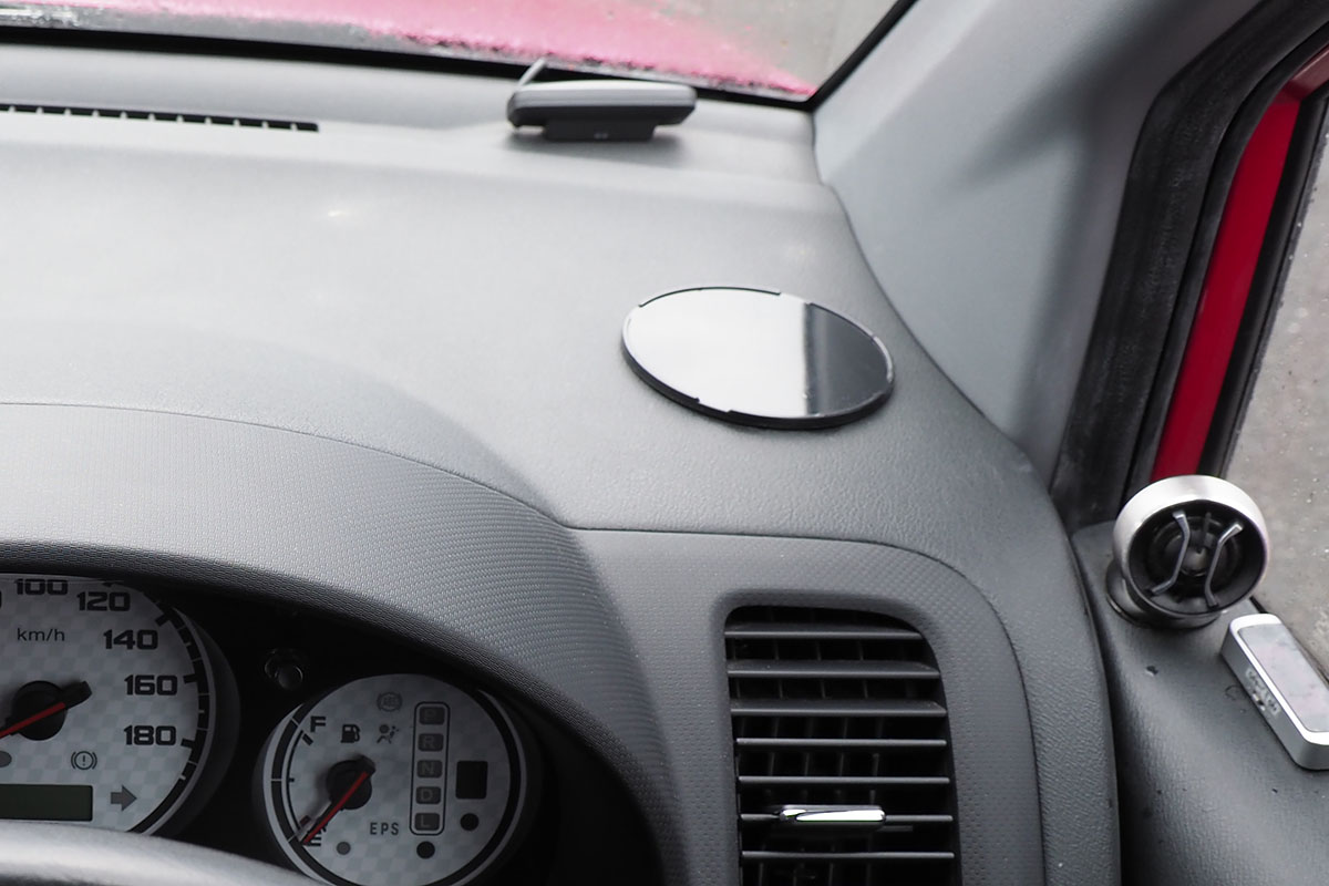 各種スマートフォンホルダーを装着する車内。運転席右側のダッシュボード上に固定しました。固定位置には、ダッシュボードに貼り付けた吸盤用プレートがあります。このクルマのダッシュボード表面のシボ加工（凸凹加工）は少し深めで吸盤が外れることが多いので、こういったプレートを使っています。