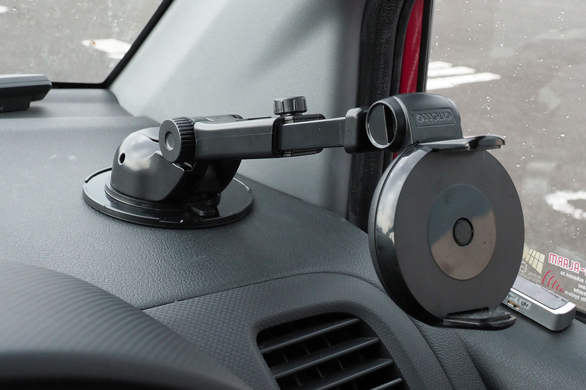 アームを逆方向から出すように固定すれば、ホルダーをさらに手前に出せます。粘着式吸盤は強力で、写真のようなプレートに固定すれば「外すのが大変なほどの固定力」です。写真のように、アームを最長にしつつ、端末を浮かせた状態でも大丈夫（ただしこの状態で走ると端末画面が振動で見えにくくなります）。このクルマのダッシュボードのシボ加工は深めですが、試してみたところ、この吸盤だと安定的に固定できました。