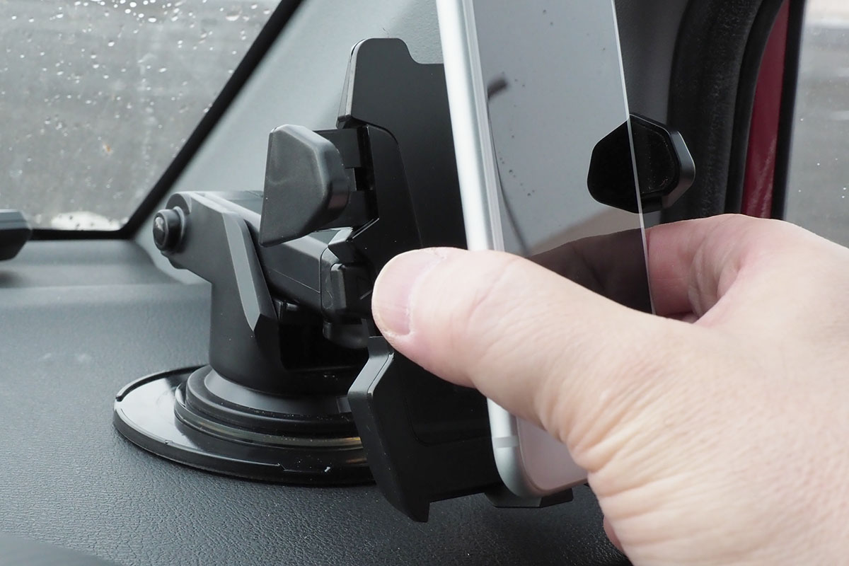 片手でホルダーから外すこともできます。赤矢印の部分を指で押すとホルダーが開きますので、そのまま端末を引き抜けばOK。その状態でホルダーが開いたまま固定されますので、再度端末をホルダーに置けば自動的に保持。脱着が片手で行える自動ホルダーというわけです。