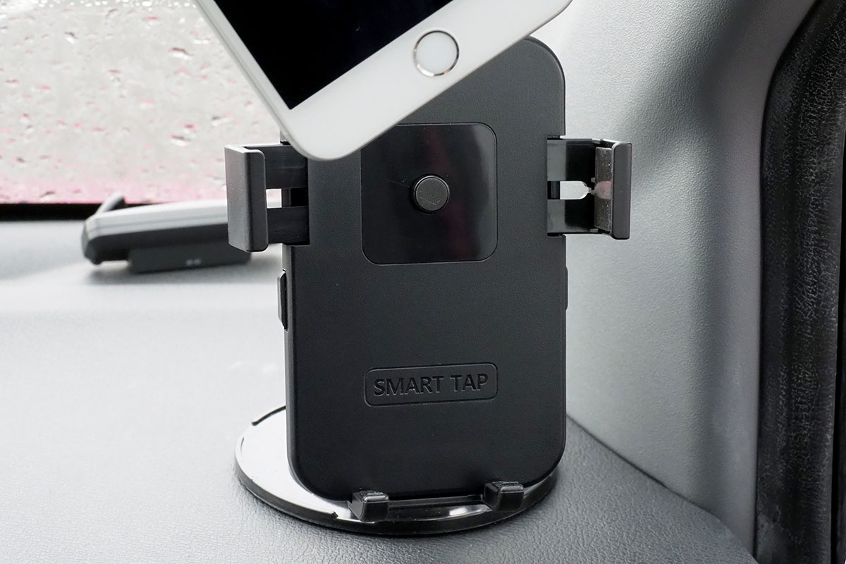 車内に設置した様子。ホルダー中央の丸いボタンが押されるようスマートフォンを置くと、自動的にホルダーが閉じて端末が固定されます。端末の向きや角度も十分な自由度をもって調節できます。