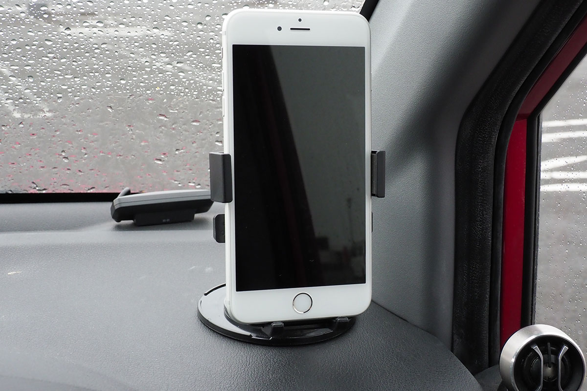 車内に設置した様子。ホルダー中央の丸いボタンが押されるようスマートフォンを置くと、自動的にホルダーが閉じて端末が固定されます。端末の向きや角度も十分な自由度をもって調節できます。