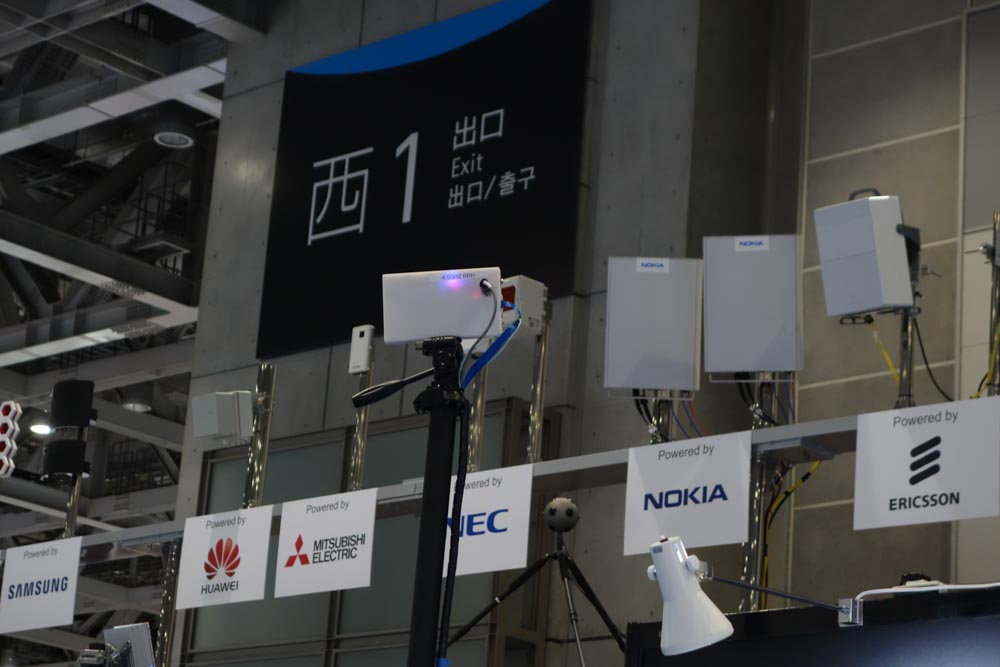 中央下、ノキアとNECのロゴパネルの間にあるのがOZOのカメラ。映像は右上のアンテナから中央のアンテナまで5Gで転送されていた