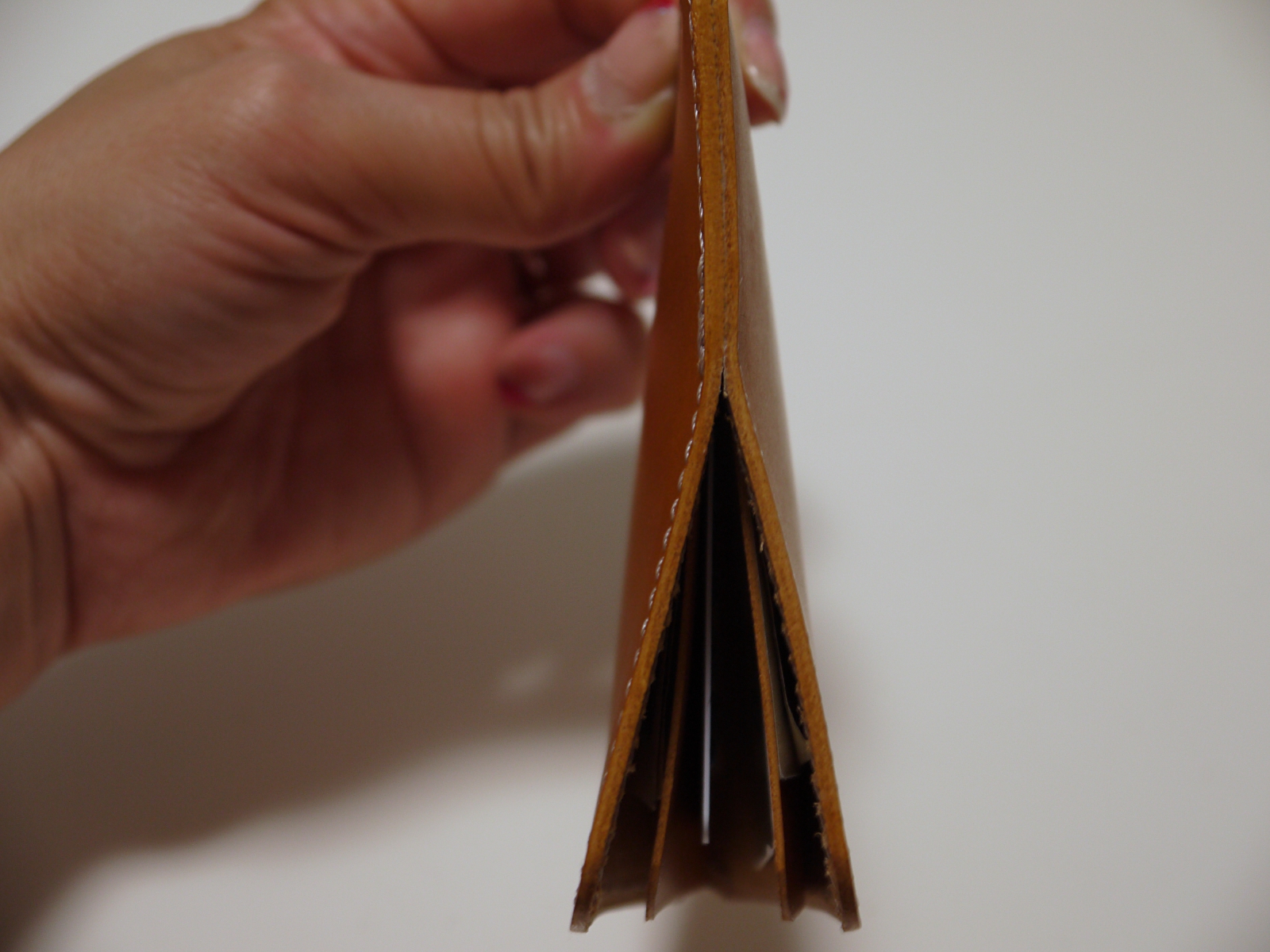 勢いよく縦に振りおろしたり縦方向の衝撃を加えれば重みのあるプラスチックカードなどは落ちてしまうが、意地悪なほど振り回さなければ中身が出てくることはない