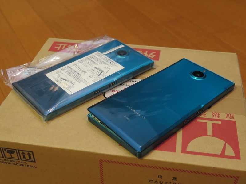 送られてきた交換用電話機（左）と背面カバーが開いてしまった自分の端末。交換用電話機は新品と変わらないほどのきれいさでした