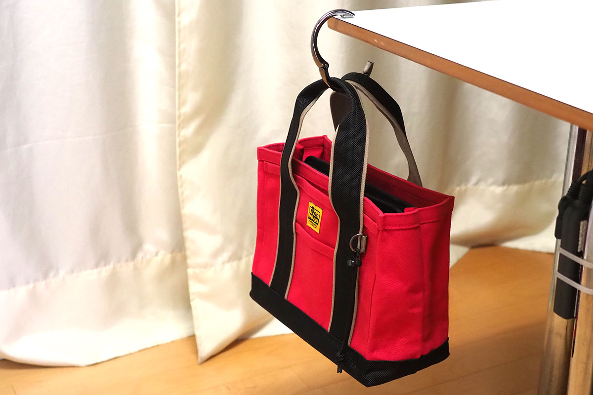 通称「バッグハンガー」として売られている「バッグを吊すための小道具」。取っ掛かりのないテーブルなどに、臨時的にバッグなどを吊しておくことができるグッズです。