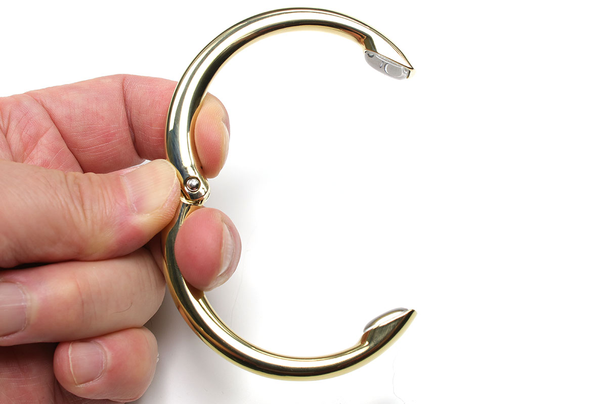 定番バッグハンガー「clipa」。現在発売されている「clipa 2」（写真で金色のほう）は耐荷重15kg・自重48gです。従来品（写真でガンメタのほう）は耐荷重21kg。「clipa 2」は耐荷重が少し下がった後継品ですが、やや軽くスマートになっています。バネを内蔵していて、力が加わらなければ「Ｏ」状態に閉じています。実勢価格には開きがありますが、だいたい3000円前後です。