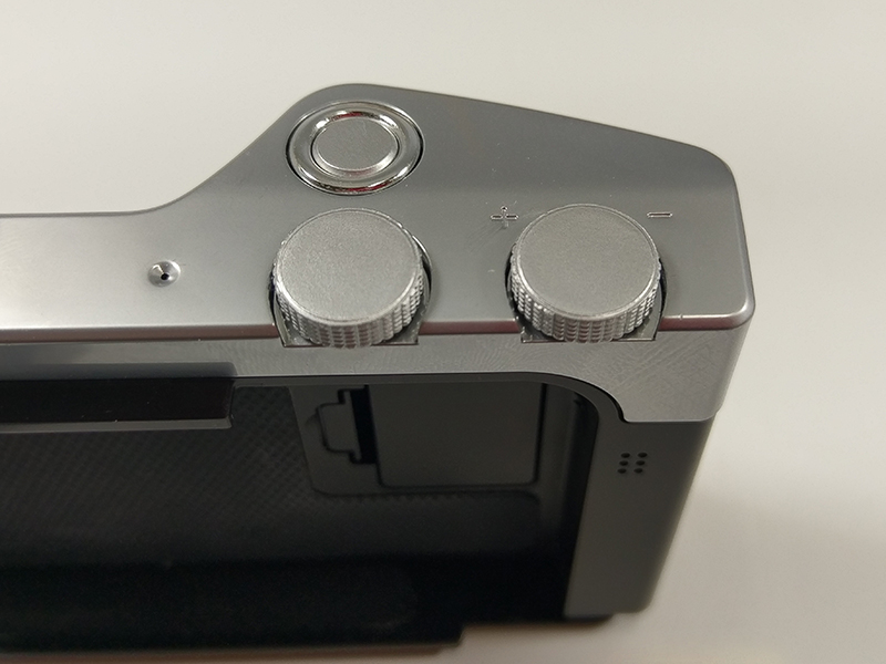 奥がシャッターボタン。手前のダイヤルは初期設定では左がモード切替