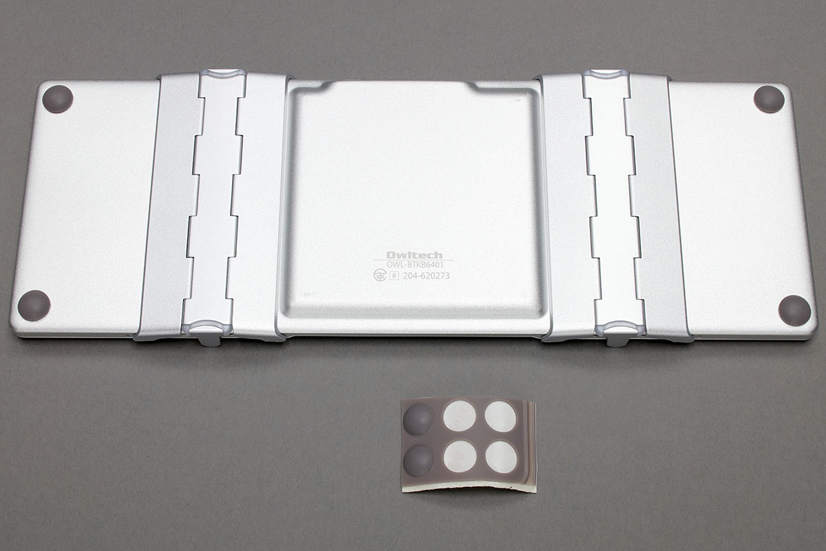 展開時の裏面。底面の左右端付近は机面から浮いた状態になり、そのままでも使えなくはありませんが、打鍵圧によってはキーボード全体が傾くことも。付属のゴム足を貼るとその問題は解消されます。