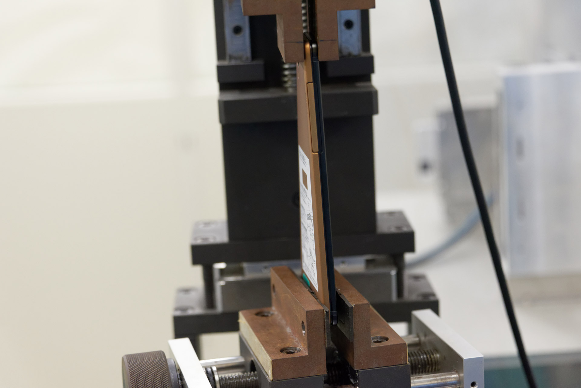 捩り試験。端末の上下で把持し、5kgの力で1万回ねじりを繰り返す。このデモでは筐体の変形がわかりやすいようにより強い力でねじられていたが、それでも端末に問題は発生していなかった