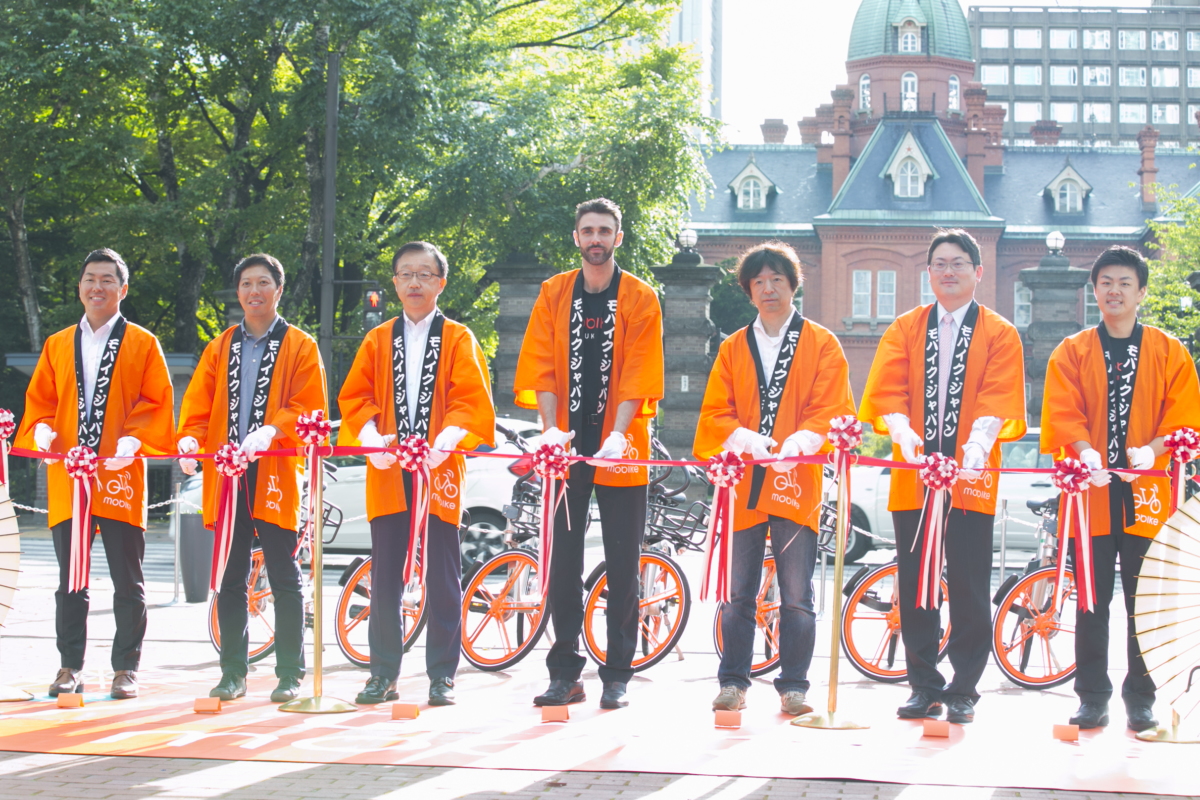 写真左より石屋製菓代表取締役社長の石水創氏、 サツドラホールディングス代表取締役社長の富山浩樹氏、 札幌市副市長の町田隆敏氏、モバイク国際展開本部長のクリス・マーティン氏、 No Maps実行委員会 委員長／クリプトン・フューチャー・メディア株式会社 代表取締役の伊藤博之氏、セコマ代表取締役副社長の赤尾洋昭氏、モバイク・ジャパンGM代理の木嵜基博氏