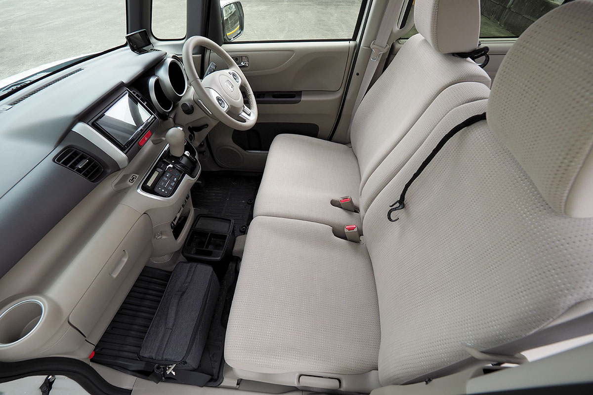 左は助手席側窓あたりから前部座席を見た様子。右は前部座席をハンドル上くらいから見た様子。前部座席は、運転席と助手席に分かれていますが、形状的にも広さ的にもベンチシートといった感じ。助手席では足を組めます。