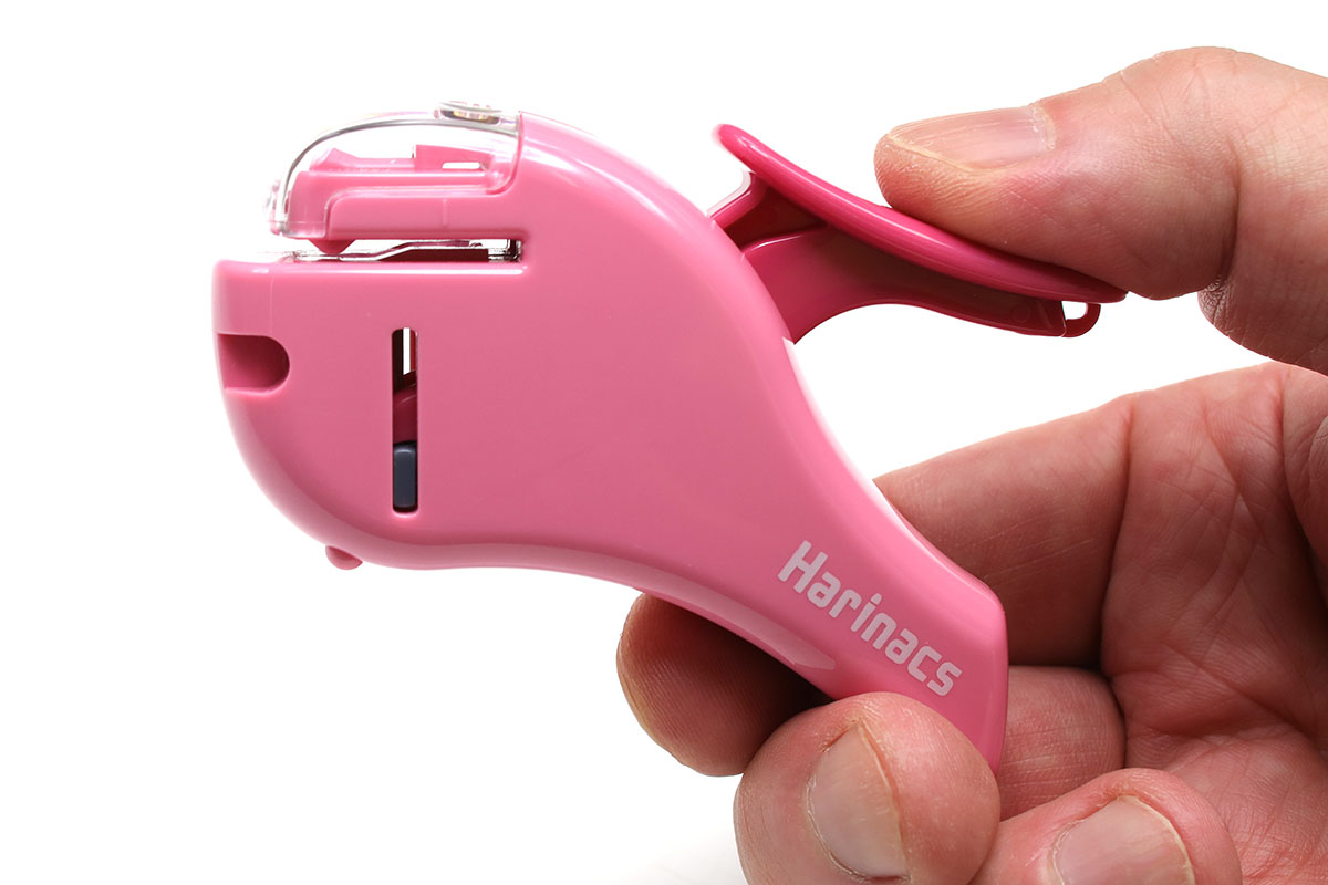 ピンクのほうが「ハリナックス コンパクトα」。5枚までしか綴じられませんが、ポケッタブルなサイズです。紙を綴じる様子は、透明のカバー越しに見えます。カバーを開いてダイレクトに見ることも可能。針なしホッチキス未経験者の前で実演すると、そのロボティックな動作に「へぇ～っ！」と感嘆してくれます。