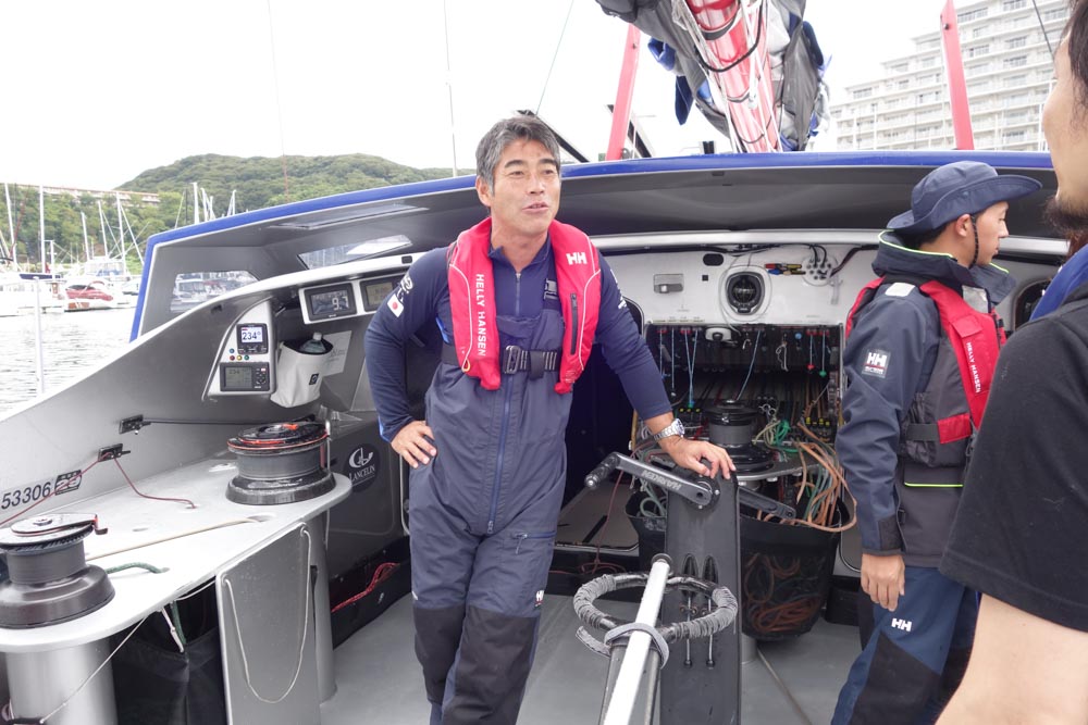 出航前に乗船中の注意点などを説明する白石氏。会場では油断すると死ぬ（レーサーヨットに限らないが）