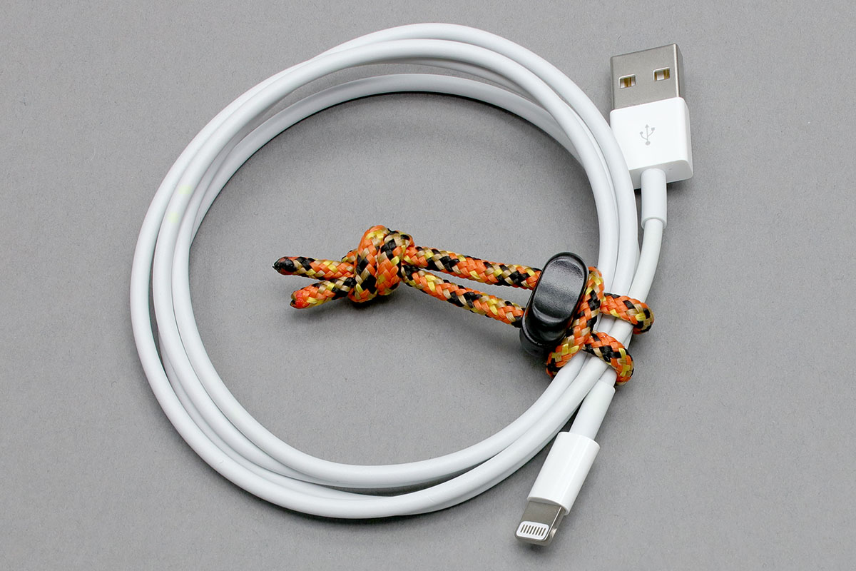 結束具でケーブルを包むようにしつつ、紐の輪にストッパーを通します。そしてキュッと絞れば結束完了。ほかの紐とストッパーの組合せでも同様のことができます。