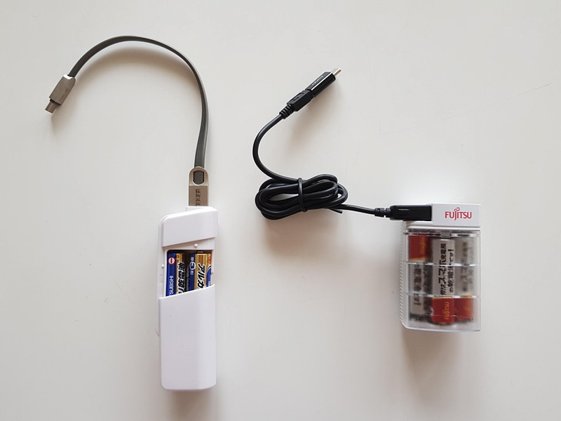 富士通の乾電池式緊急充電器（右）と同じように、単3アルカリ乾電池2本を使って緊急充電してくれるダイソーの100円充電器（乾電池含まず）