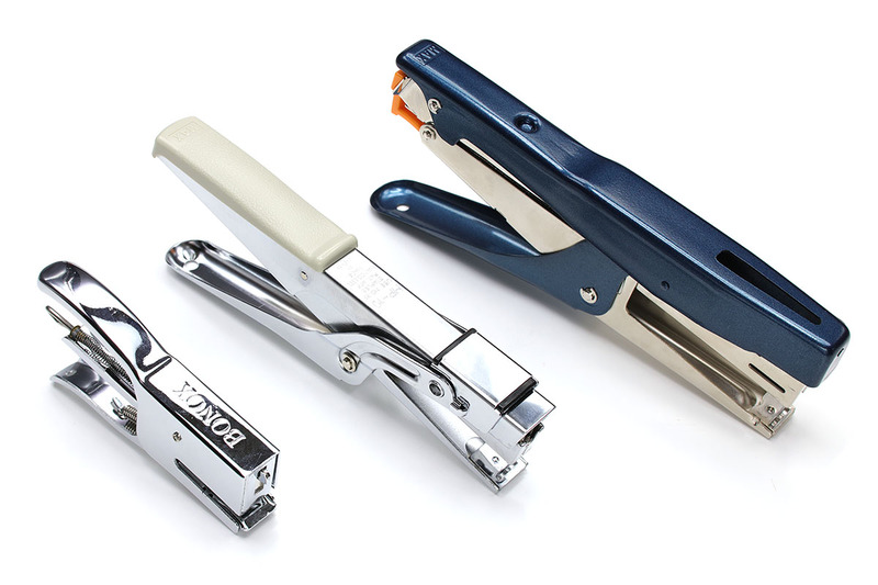 左写真はプライヤータイプのステープラー各種。右写真は据え置き型のステープラー各種です。プライヤータイプで最小のもの以外は業務用だと思われます。